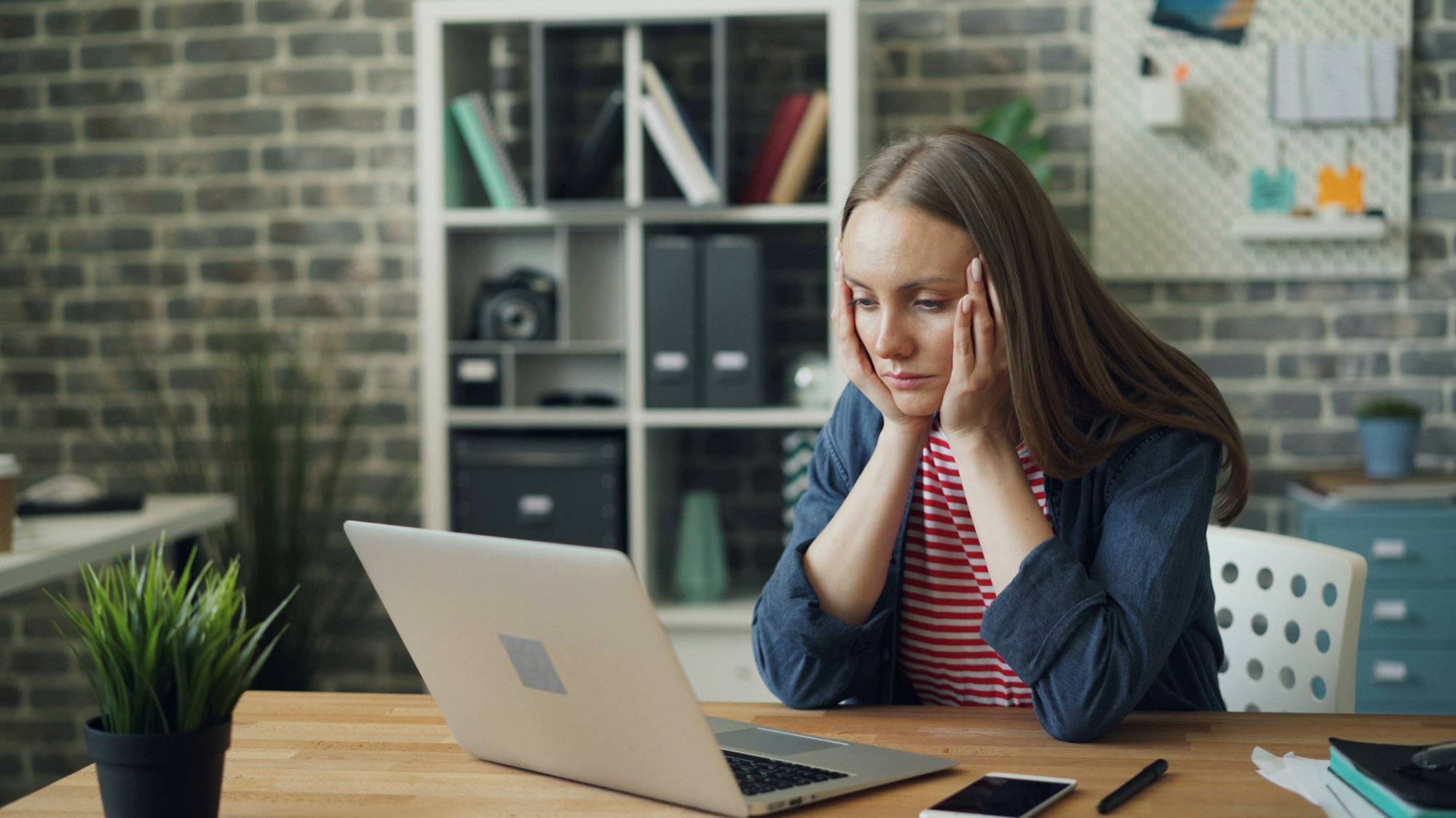 a-woman-sitting-at-a-table-with-a-laptop-in-front-of-her.jpg a woman sitting at a table with a laptop in front of her